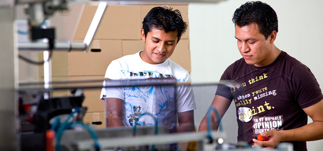 Dos hombres jóvenes trabajando en una fábrica