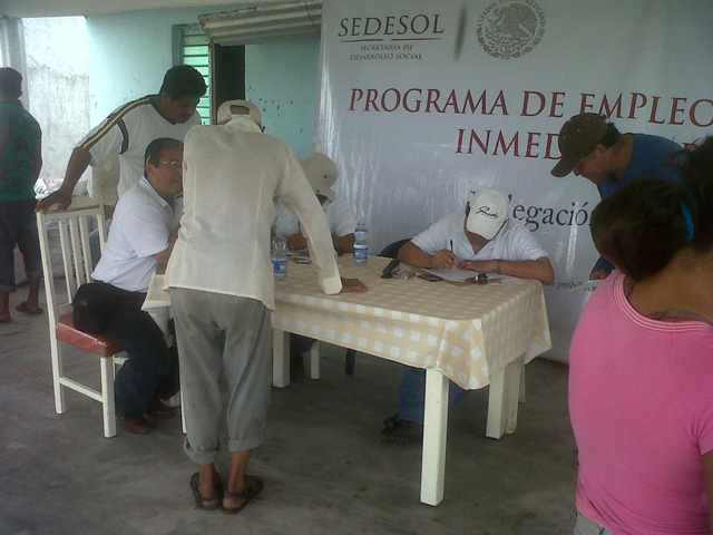 Programa de empleo inmediato - Personas apuntándose en una mesa de funcionarios